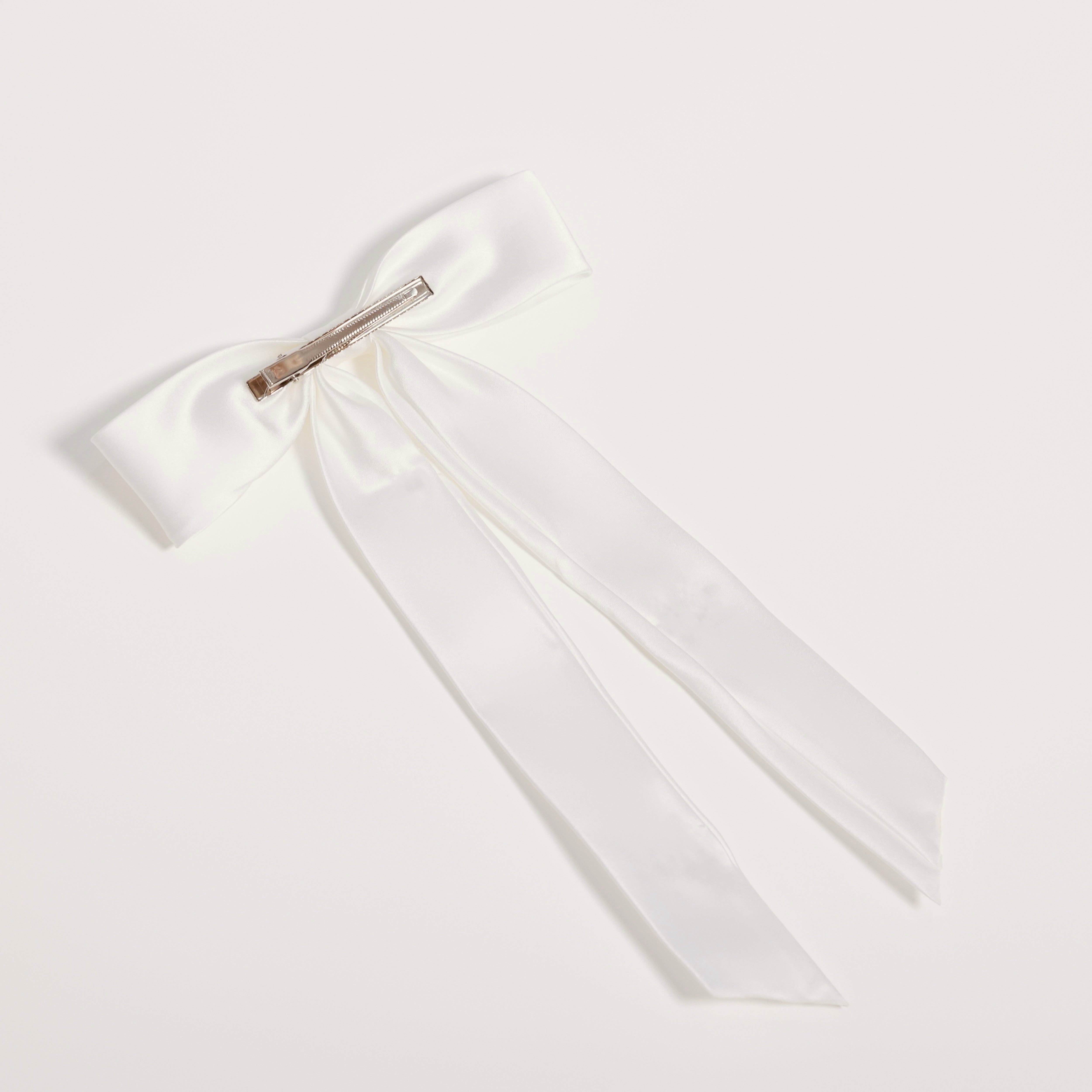 The KIKI and JOJO Girls Hand-Beaded Pearl Satin Bow Hair Clip features long tails and a silver metal barrette clasp, perfect for a flower girl, displayed on a plain white background.