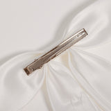 Close-up of the KIKI and JOJO Girls Hand-Beaded Pearl Satin Bow Hair Clip, featuring a metal alligator clasp—an elegant pearl hair accessory for any flower girl.