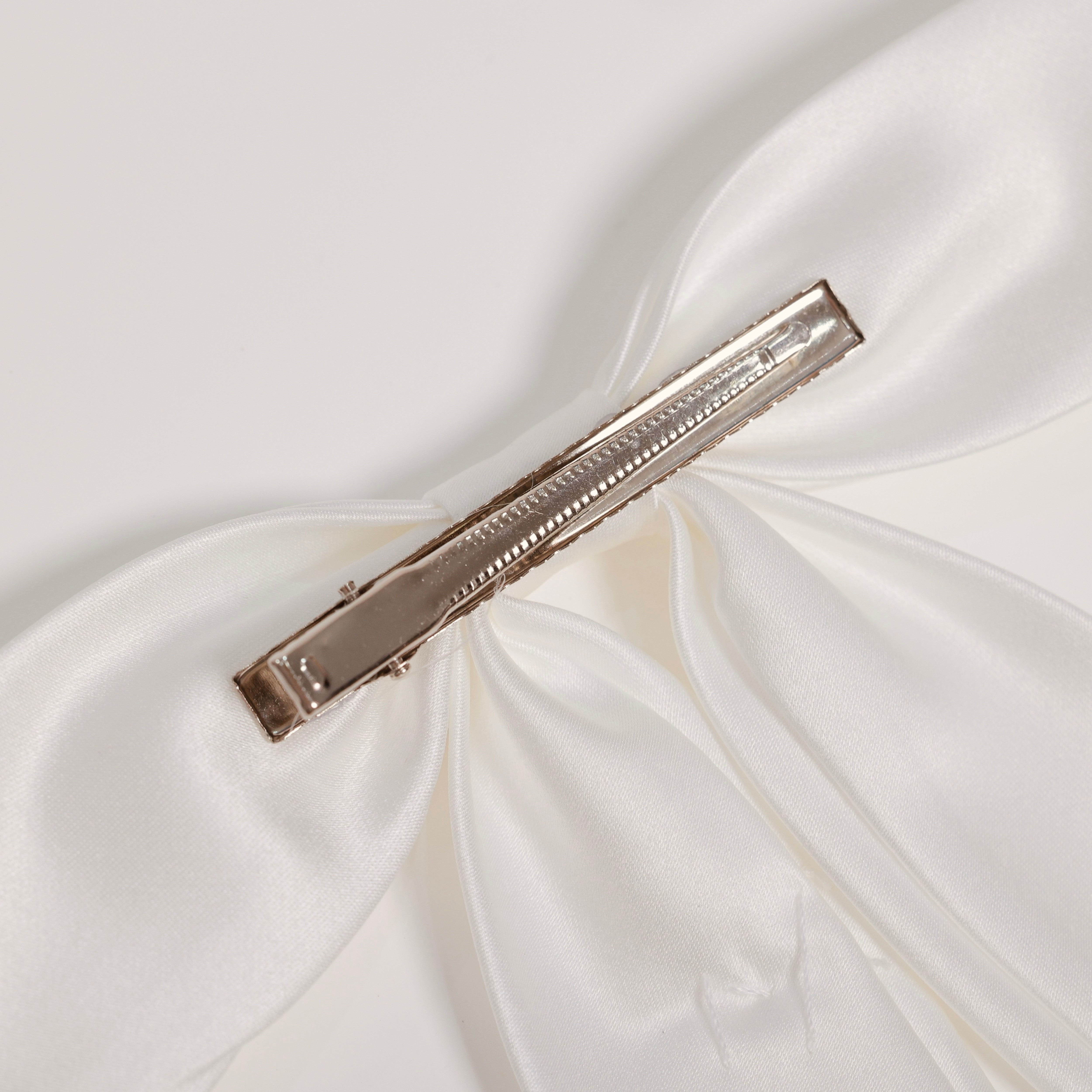 Close-up of the KIKI and JOJO Girls Hand-Beaded Pearl Satin Bow Hair Clip, featuring a metal alligator clasp—an elegant pearl hair accessory for any flower girl.