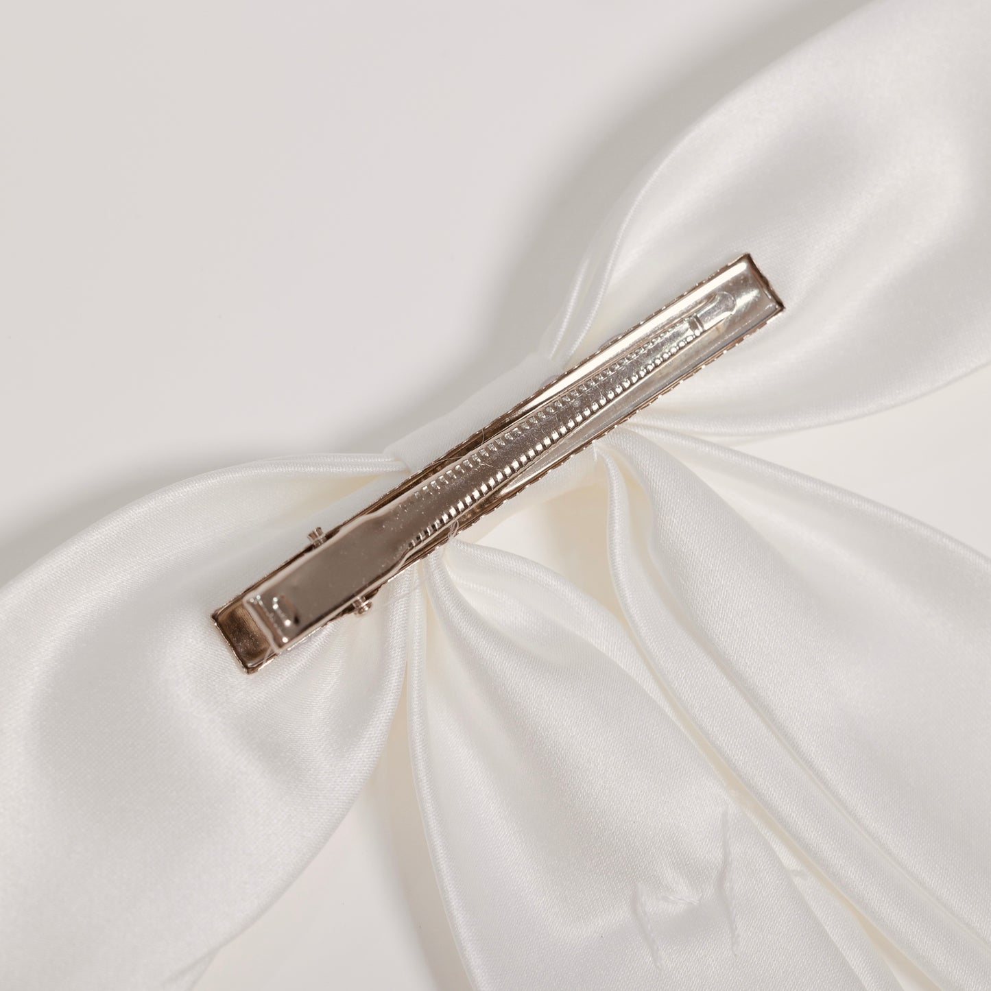 Close-up of the KIKI and JOJO Girls Hand-Beaded Pearl Satin Bow Hair Clip, featuring a metal alligator clasp—an elegant pearl hair accessory for any flower girl.