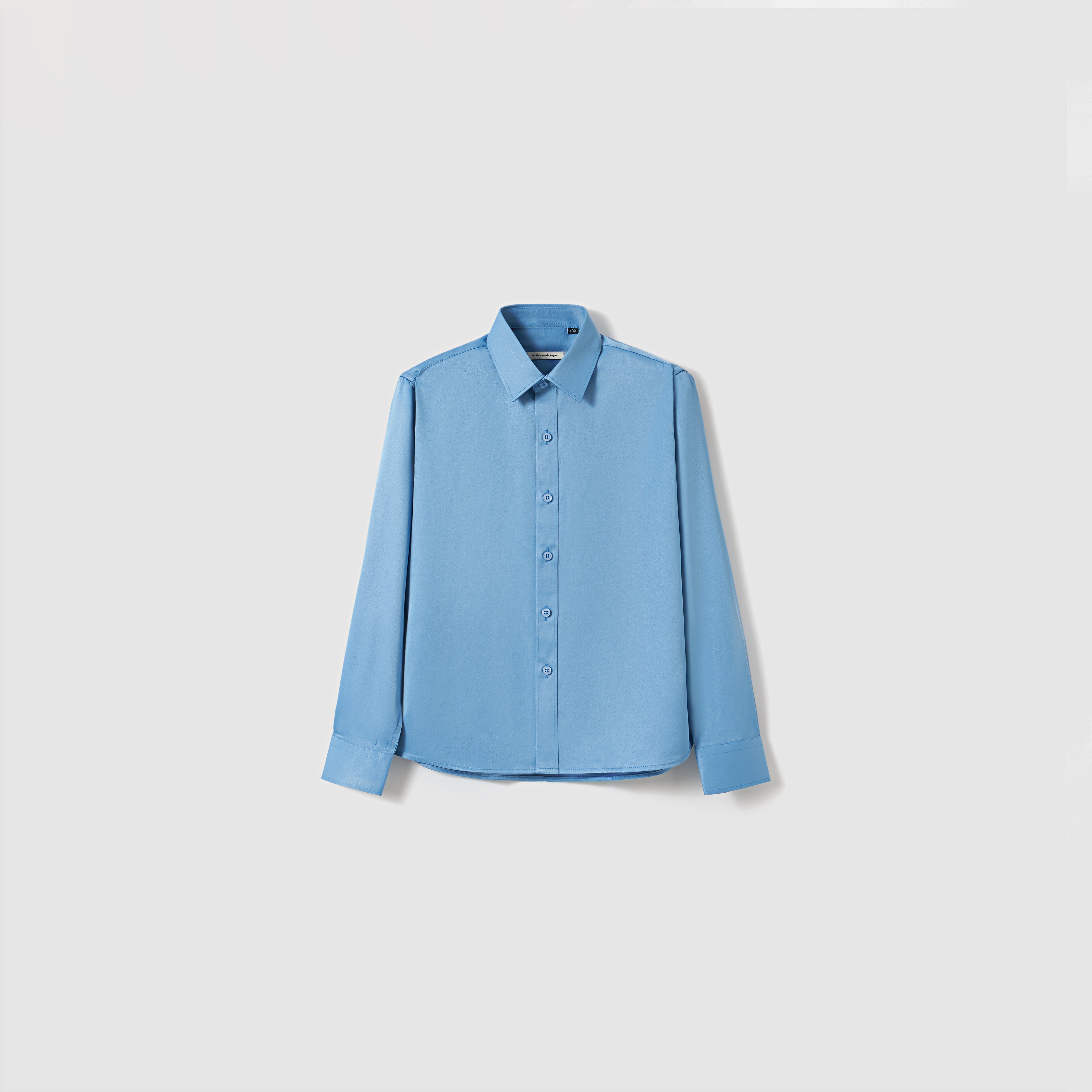The Boys Sky Blue Dress Shirt by KIKI and JOJO features long sleeves and a classic collar, shown against a plain white background.