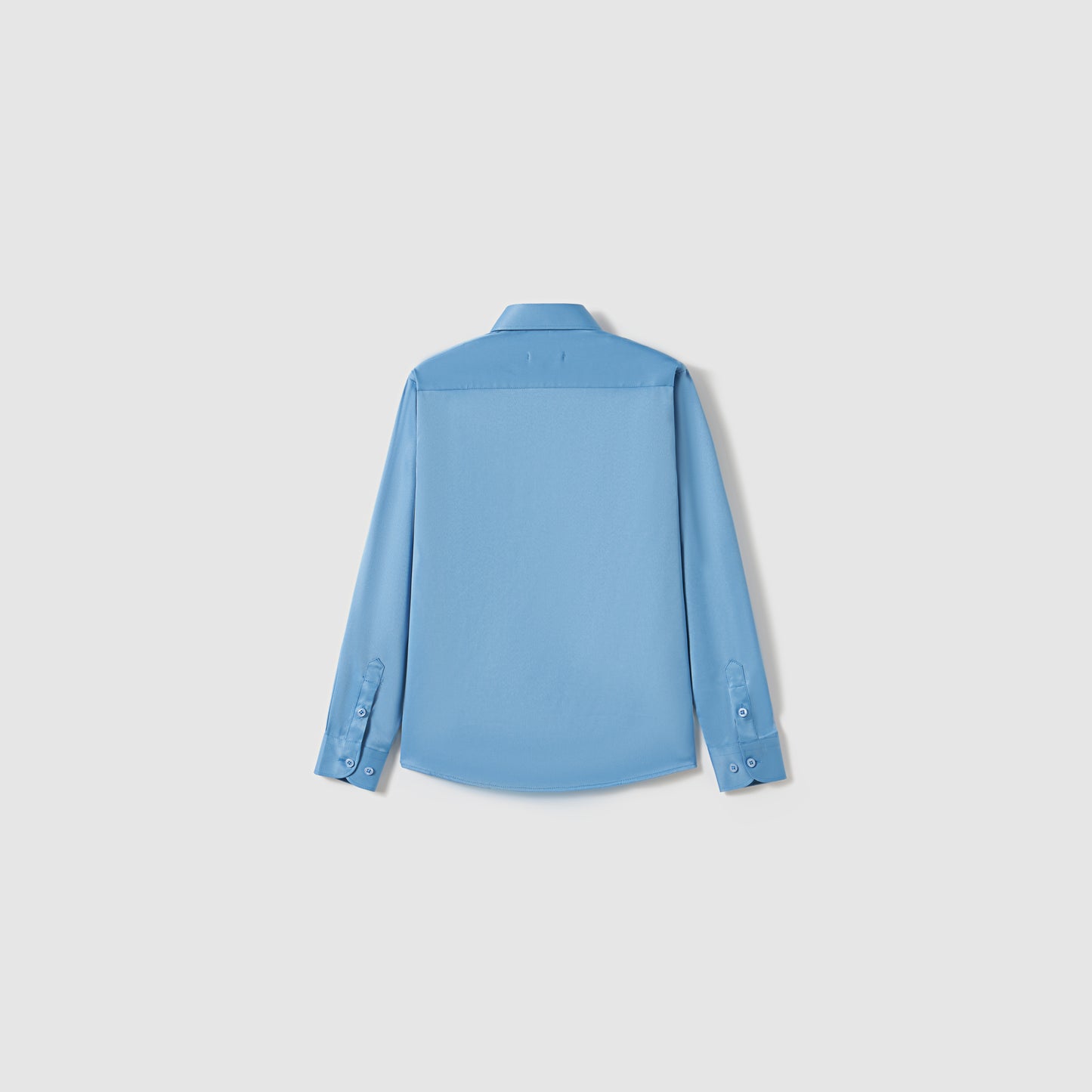 The KIKI and JOJO Boys Sky Blue Dress Shirt, shown from the back against a white background, features long sleeves and a button-up design.