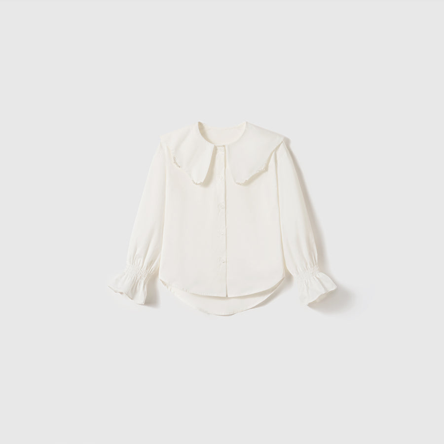 The Moonlit Whisper Blouse by KIKI and JOJO is a white vintage long-sleeve top with a wide Peter Pan collar, puffed lantern sleeves, and ruffled cuffs, shown against a plain light background.