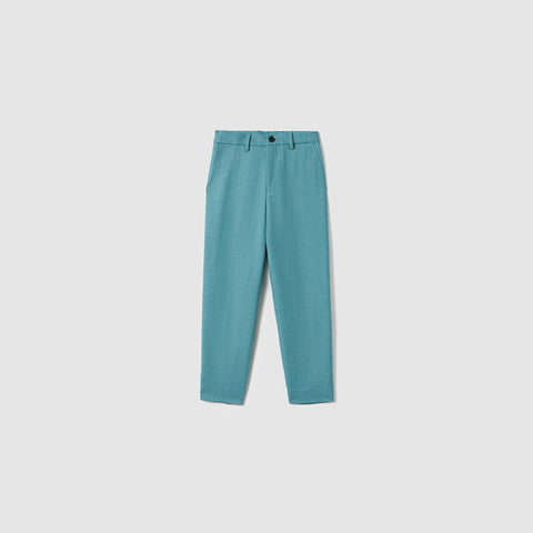 The Celeste Whimsy Suit Pants by KIKI and JOJO are turquoise, straight-leg boys' pants featuring side pockets, belt loops, and a front button with zipper closure, shown on a plain light grey background.