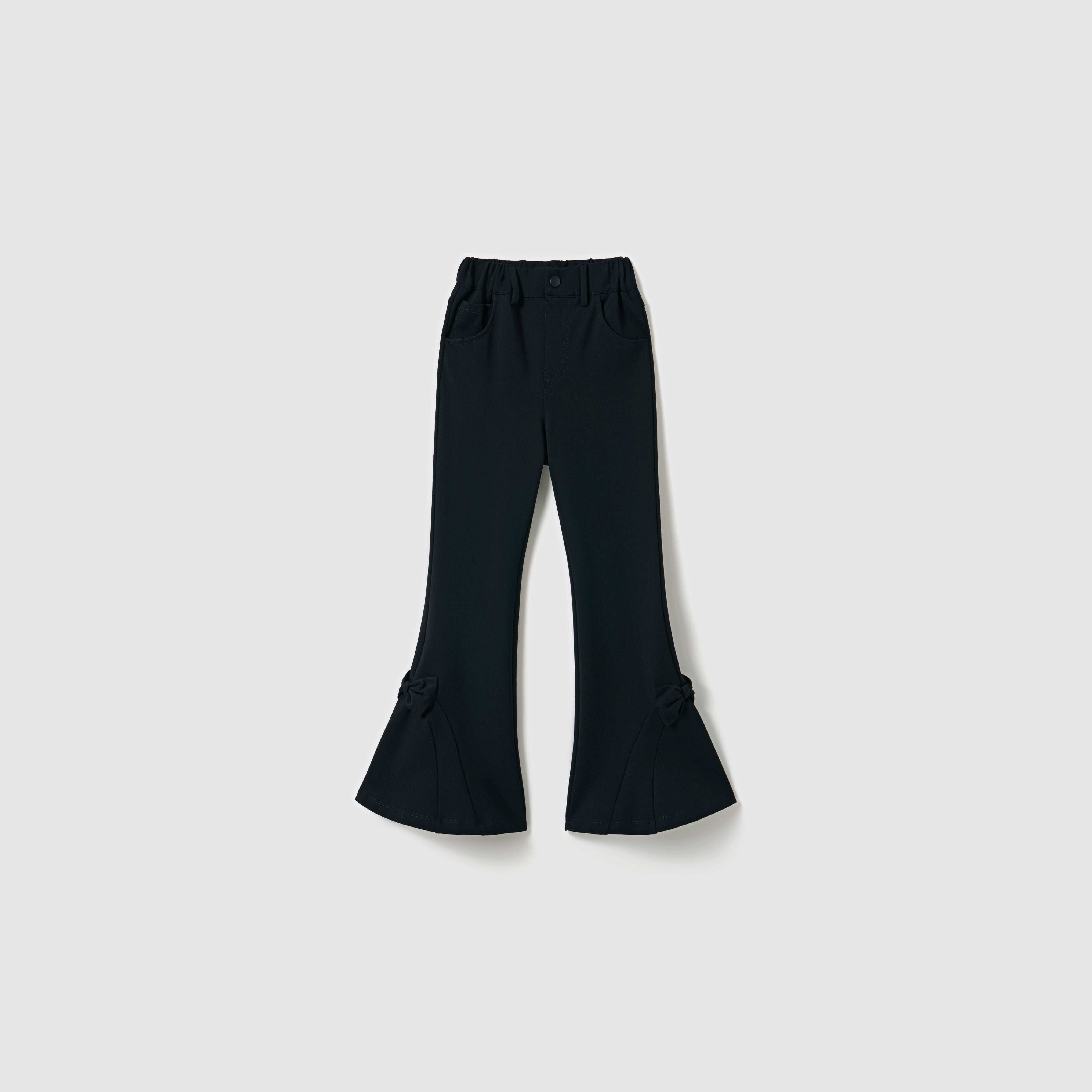 The Petal Whisper Dress Pants by KIKI and JOJO are flared black pants with an elastic waistband, side pockets, and bow accents at the lower legs, crafted from stretchy fabric and shown against a plain light background.