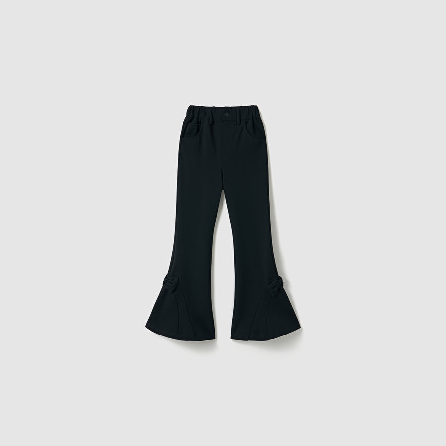 The Petal Whisper Dress Pants by KIKI and JOJO are flared black pants with an elastic waistband, side pockets, and bow accents at the lower legs, crafted from stretchy fabric and shown against a plain light background.