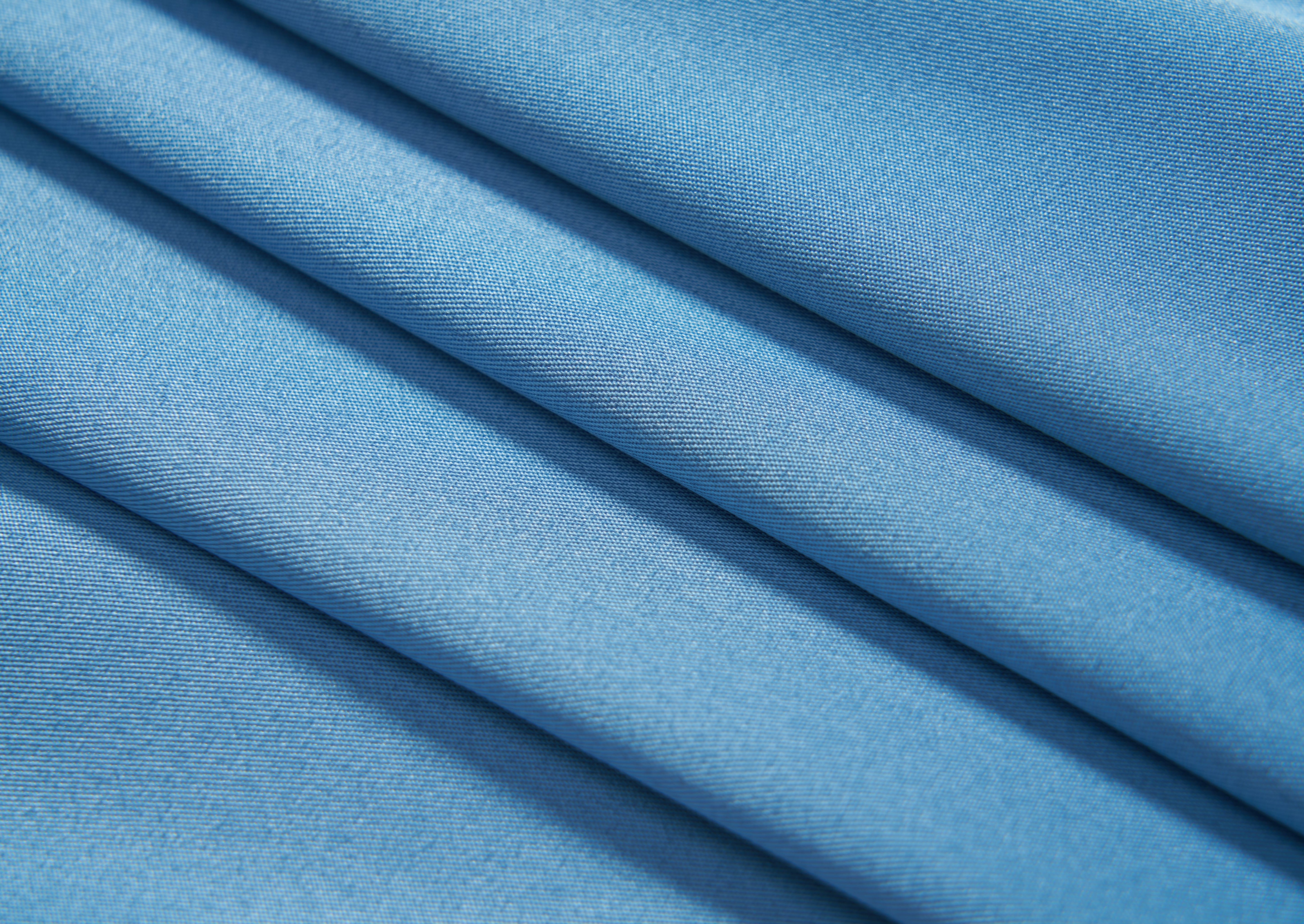 Close-up of a neatly folded KIKI and JOJO Boys Sky Blue Dress Shirt fabric, featuring a subtle diagonal weave pattern—ideal for a tailored, stylish look.