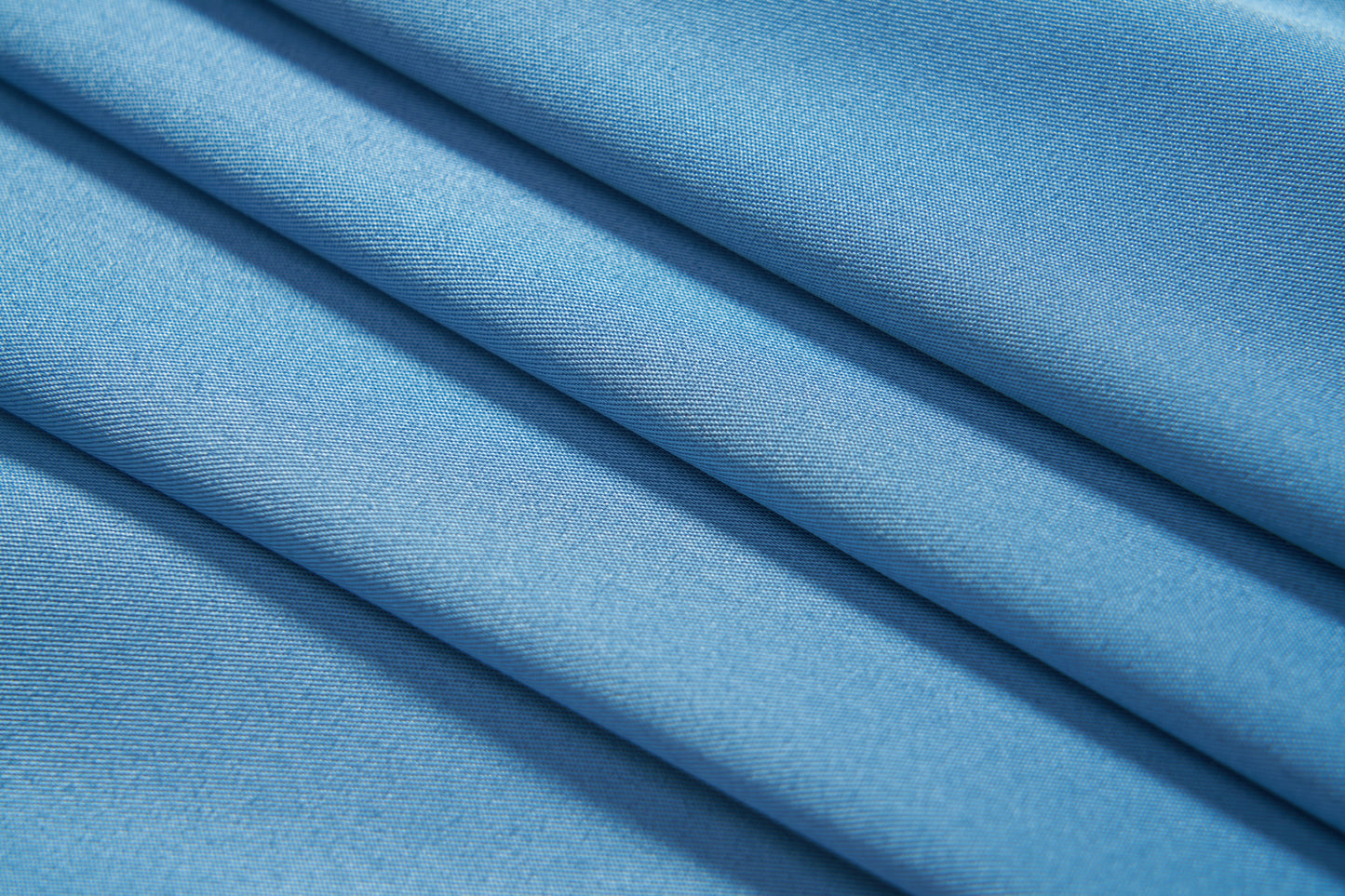 Close-up of a neatly folded KIKI and JOJO Boys Sky Blue Dress Shirt fabric, featuring a subtle diagonal weave pattern—ideal for a tailored, stylish look.