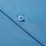 Close-up of KIKI and JOJO Boys Sky Blue Dress Shirt fabric, featuring visible stitching and two plastic buttons on the placket.