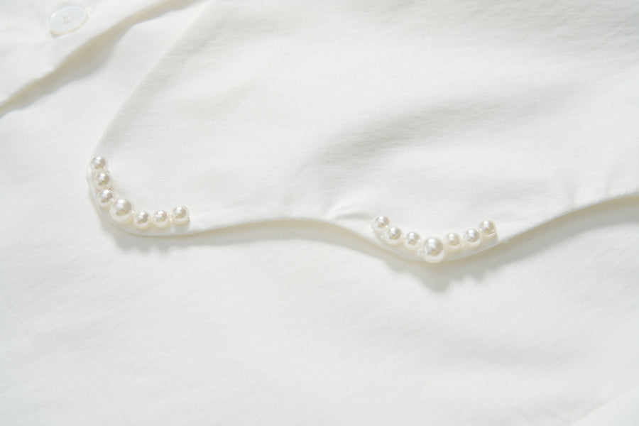 Close-up of the Moonlit Whisper Blouse by KIKI and JOJO, showcasing pearl embellishments along the scalloped collar.