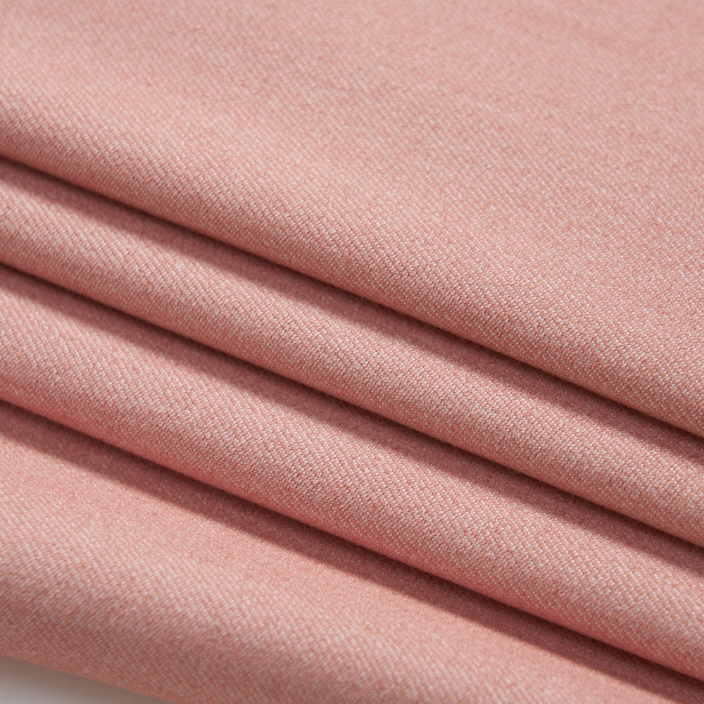 Close-up of four neatly folded layers of soft, light pink fabric with a smooth, fine texture.