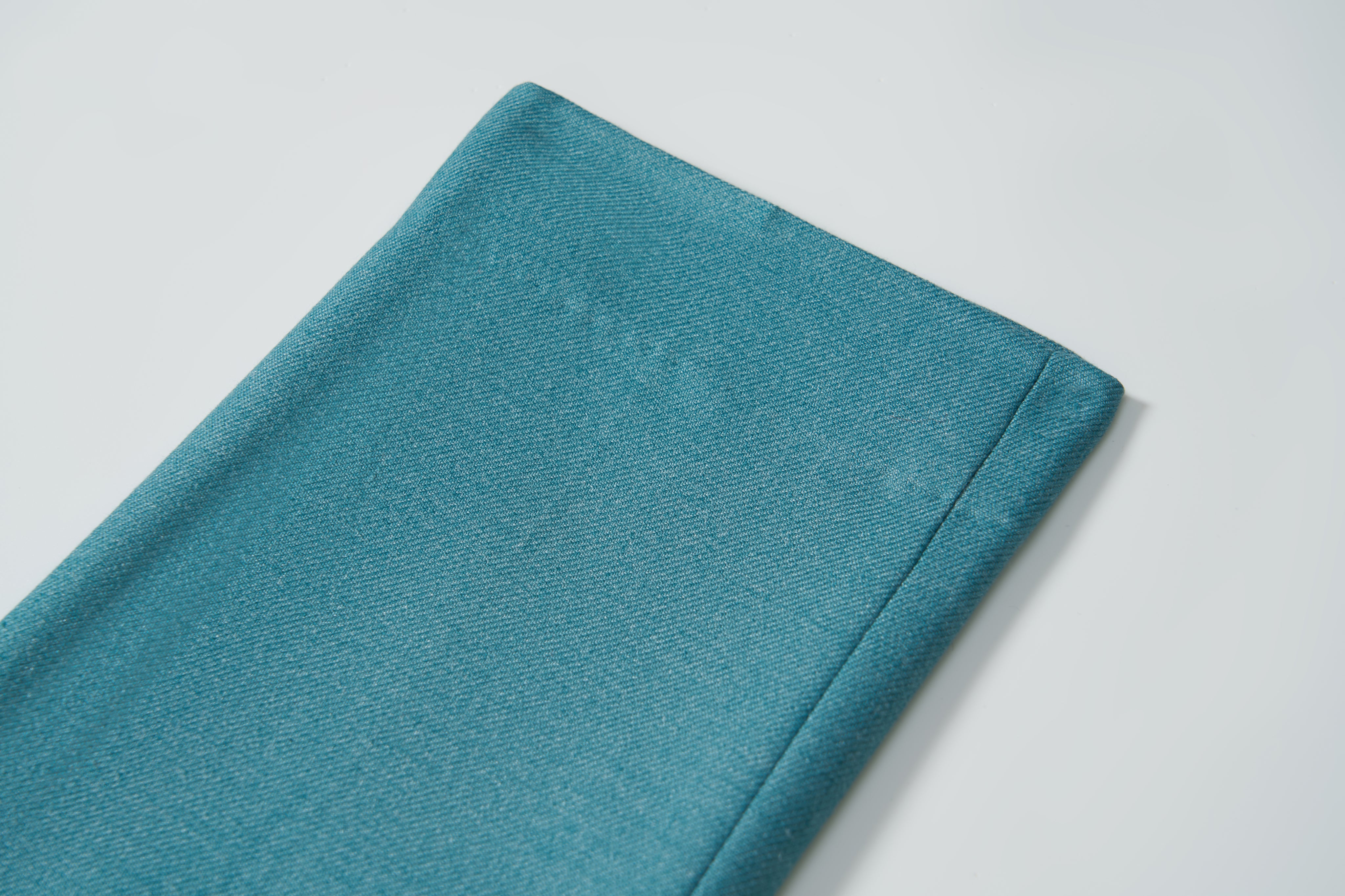 A close-up of the neatly folded Celeste Whimsy Suit Pants by KIKI and JOJO displayed on a white surface.