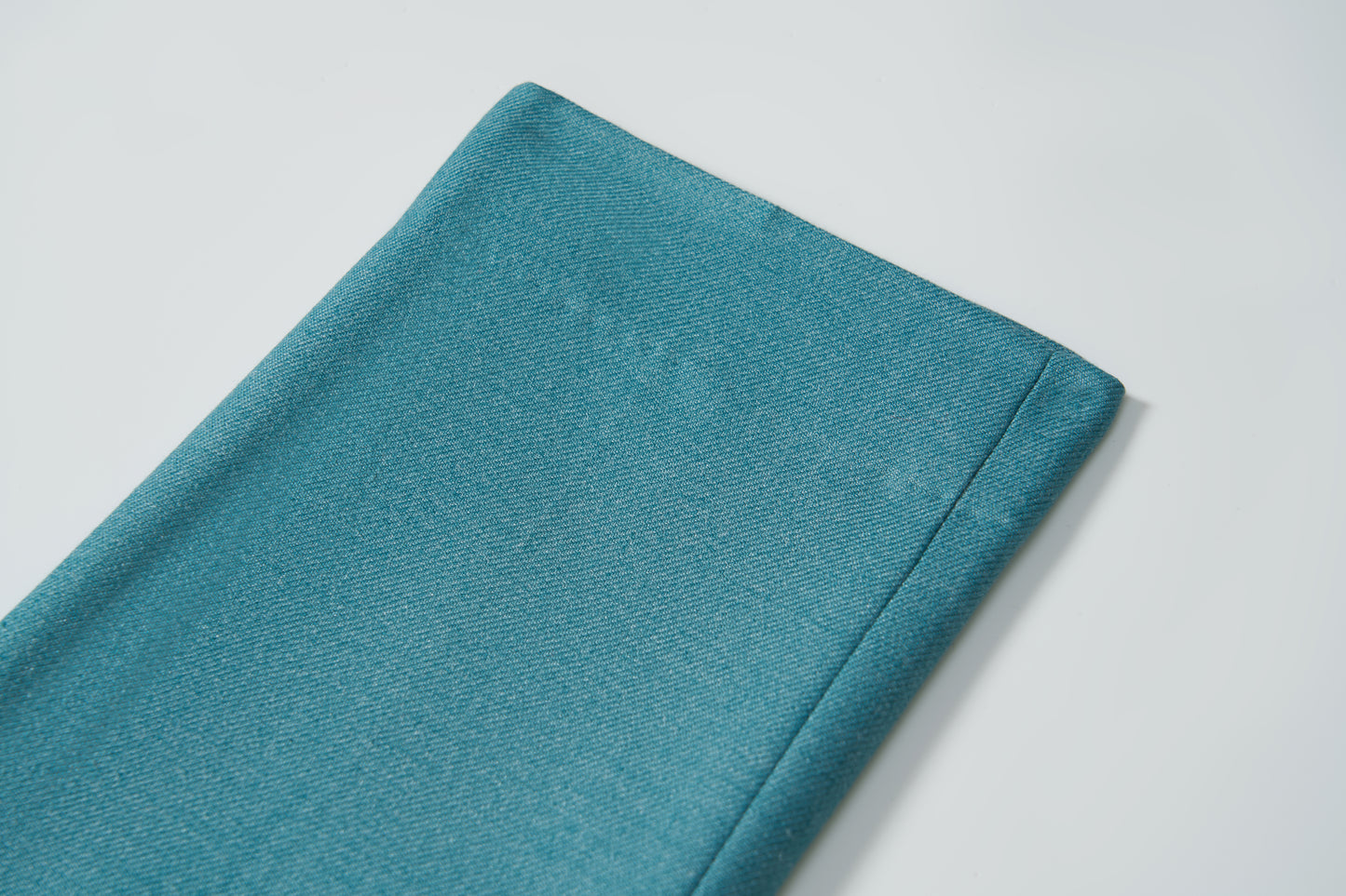 A close-up of the neatly folded Celeste Whimsy Suit Pants by KIKI and JOJO displayed on a white surface.