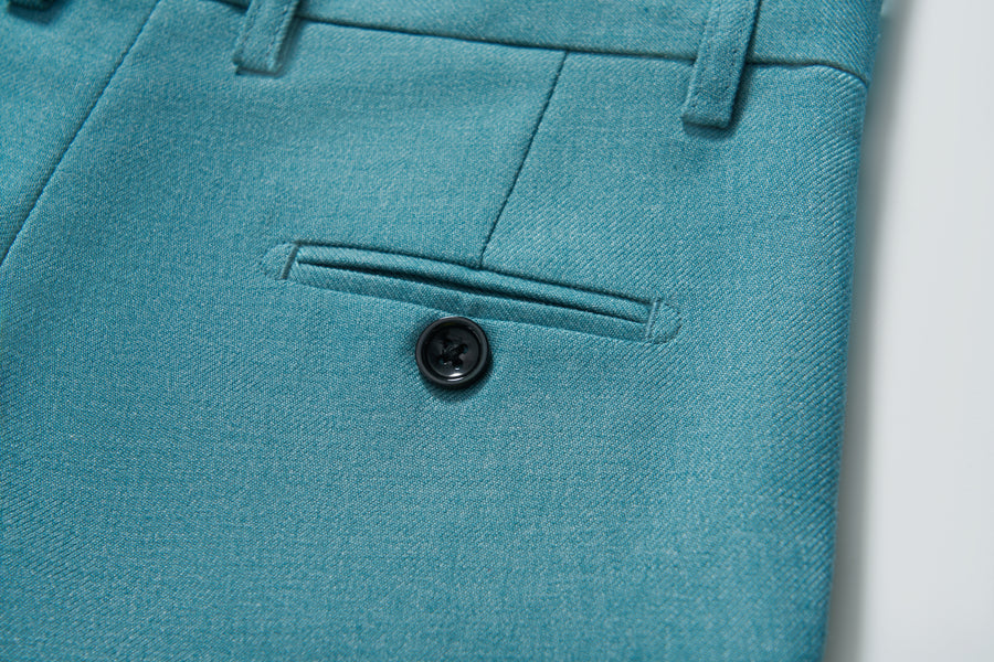 Close-up of the turquoise pocket with button on KIKI and JOJO's Celeste Whimsy Suit Pants for boys, featuring an adjustable waistband for a perfect fit.