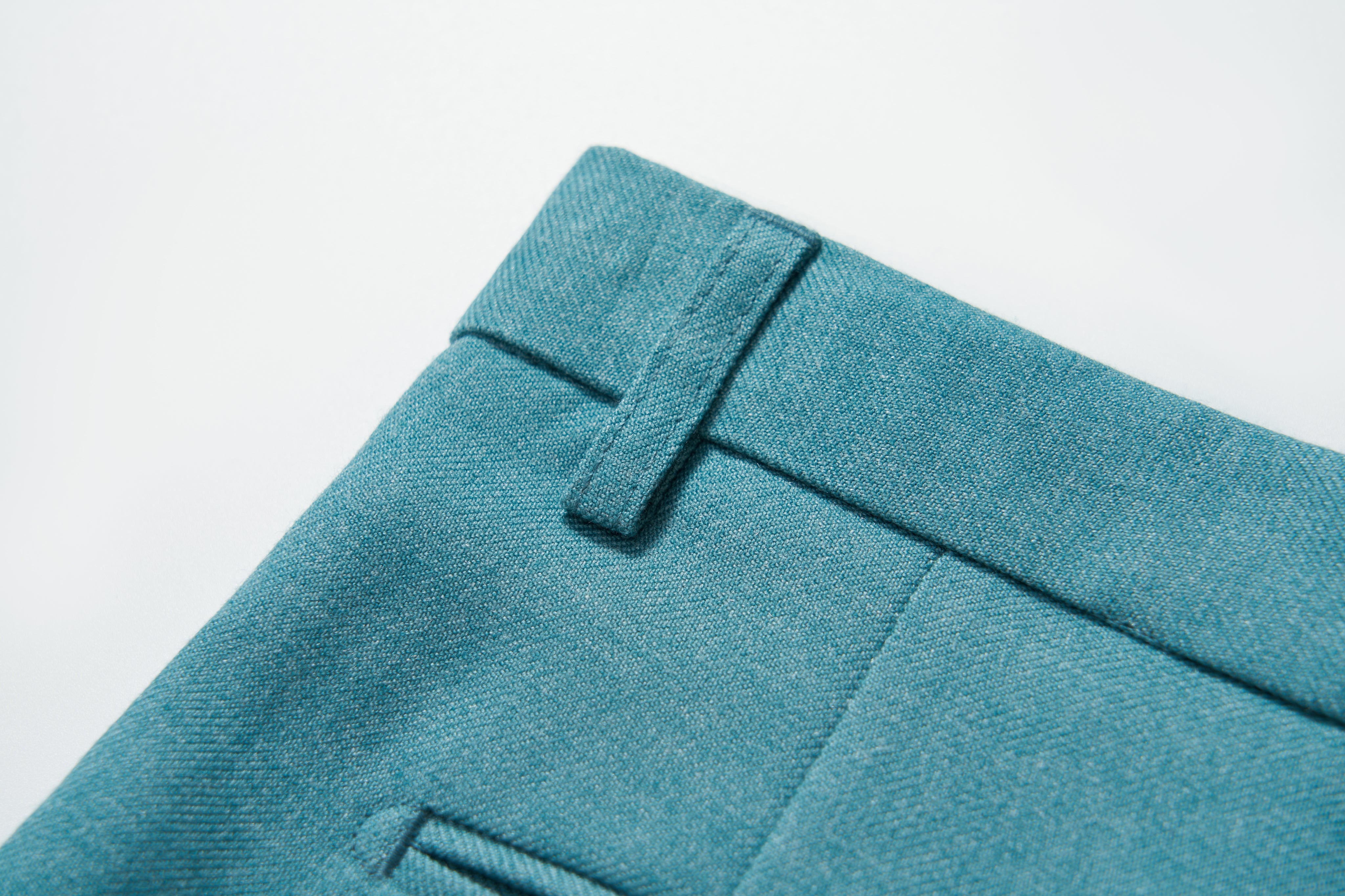 Close-up of the adjustable waistband and belt loop on KIKI and JOJO’s Celeste Whimsy Suit Pants, showcasing turquoise fabric, texture, and fine stitching.
