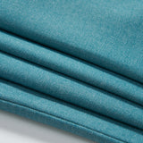 Close-up of four neatly folded layers of turquoise fabric with a smooth texture for KIKI and JOJO's Celeste Whimsy Suit Pants, ideal for boys featuring an adjustable waistband, displayed on a white surface.