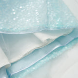 Close-up of the Feathered Whisper Dress - Blue by KIKI and JOJO: light blue sequined sheer fabric with white lining, radiating ethereal elegance—seen laid flat, highlighting its delicate off-shoulder design.