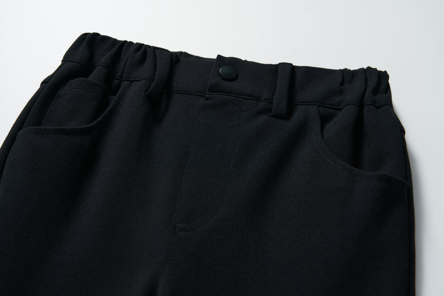 Close-up of the waistband and pockets of KIKI and JOJO's Petal Whisper Dress Pants, featuring flared black legs, stretchy fabric, an elastic waist, and button closure, shown on a white background.