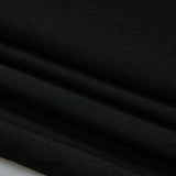 Close-up of neatly folded black fabric, showing smooth texture and clean lines.