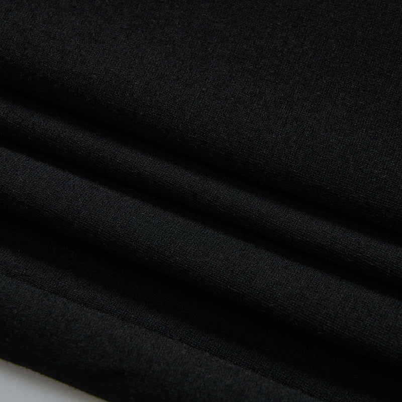 Close-up of neatly folded black fabric, showing smooth texture and clean lines.