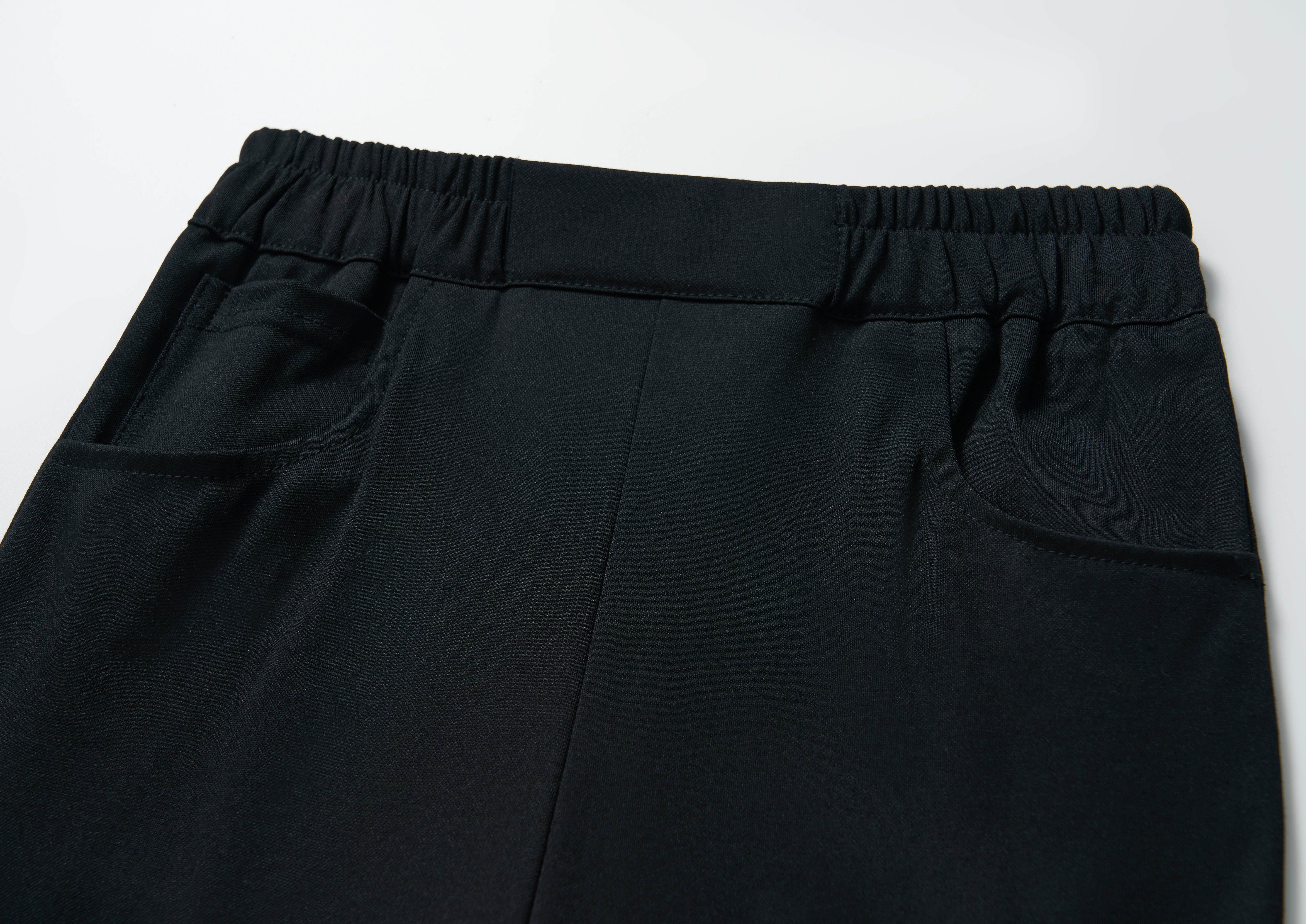 Close-up of KIKI and JOJO’s Echo Whisper Dress Pants featuring a flared black design, elastic waistband, and two side pockets, shown on a white background.