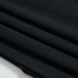 Close-up of neatly folded dark fabric with a smooth texture, showing four visible folds against a white background.