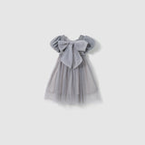The KIKI and JOJO Dusk Whisper Dress is a glittering gray tulle dress with short puff sleeves and a large front bow, shown against a plain white background.