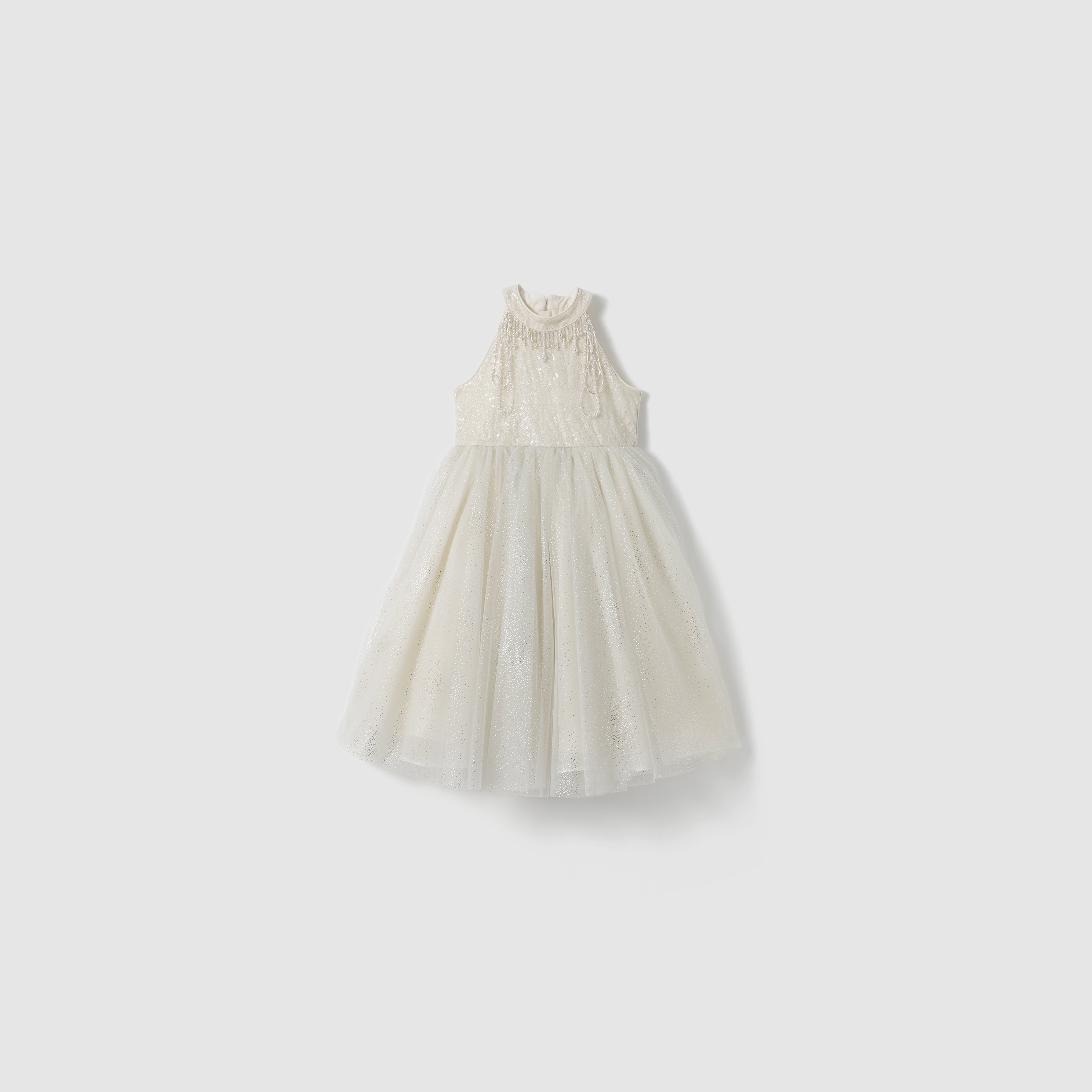 The Gilded Whisper Dress by KIKI and JOJO is a sleeveless white lace dress with a beige tulle skirt, high neckline, and fitted bodice, displayed on a plain light background.