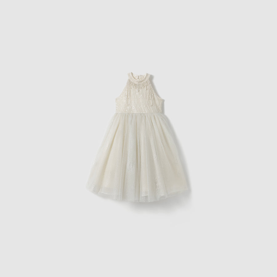 The Gilded Whisper Dress by KIKI and JOJO is a sleeveless white lace dress with a beige tulle skirt, high neckline, and fitted bodice, displayed on a plain light background.