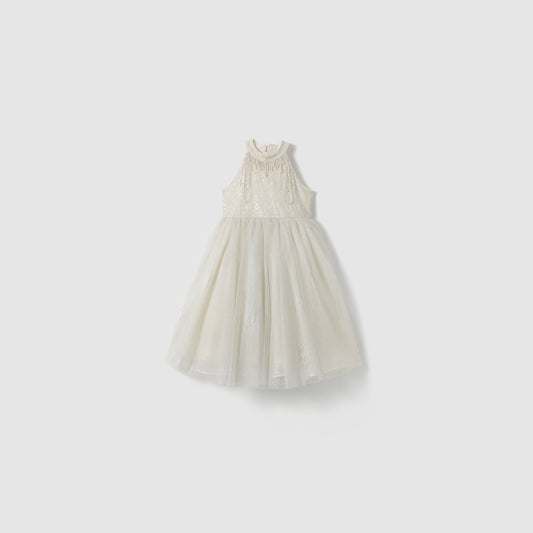 The Gilded Whisper Dress by KIKI and JOJO features a sleeveless beige tulle design with lace detailing, a high neckline, and a fitted bodice, shown against a plain light background.