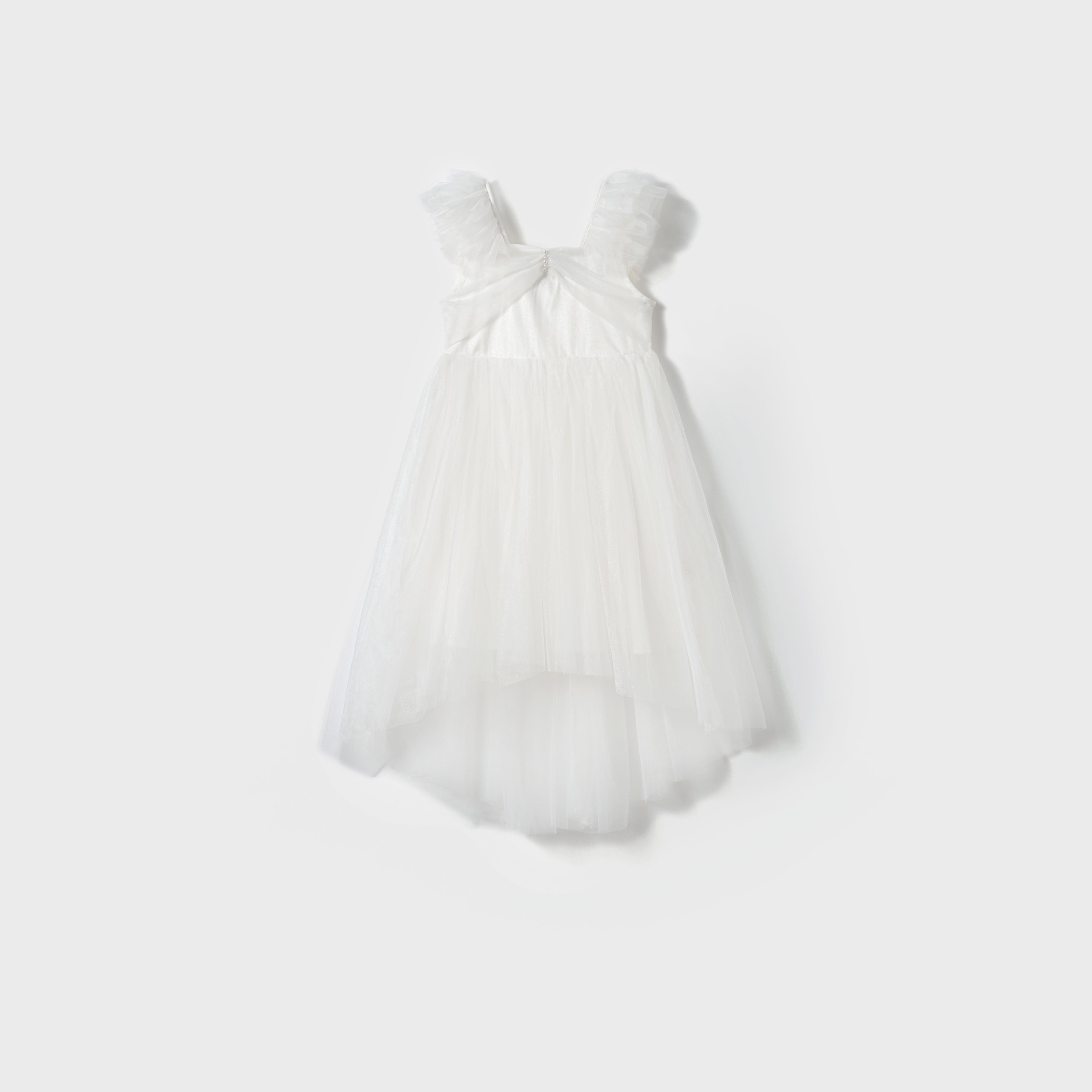 The Cloud Whisper Dress by KIKI and JOJO is a white sleeveless flowy dress with ruffled shoulder straps and a layered tulle skirt, shown against a plain light gray background.