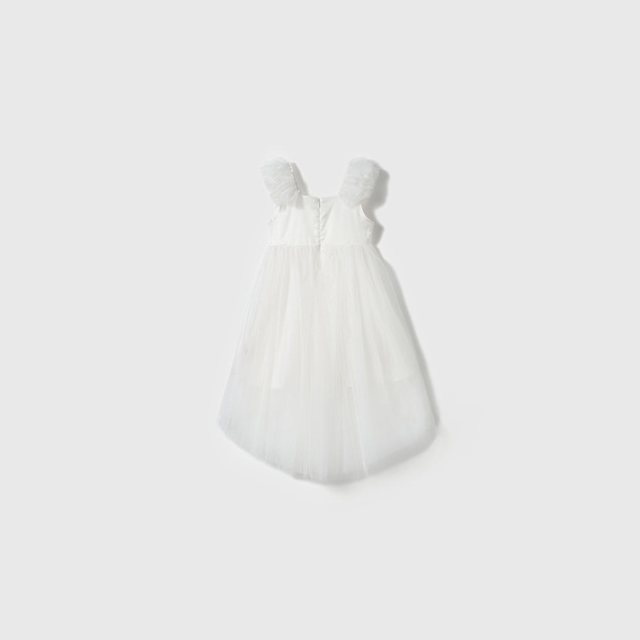 The Cloud Whisper Dress by KIKI and JOJO features ruffled shoulder straps and a flowy ivory tulle overlay, displayed against a plain light background.
