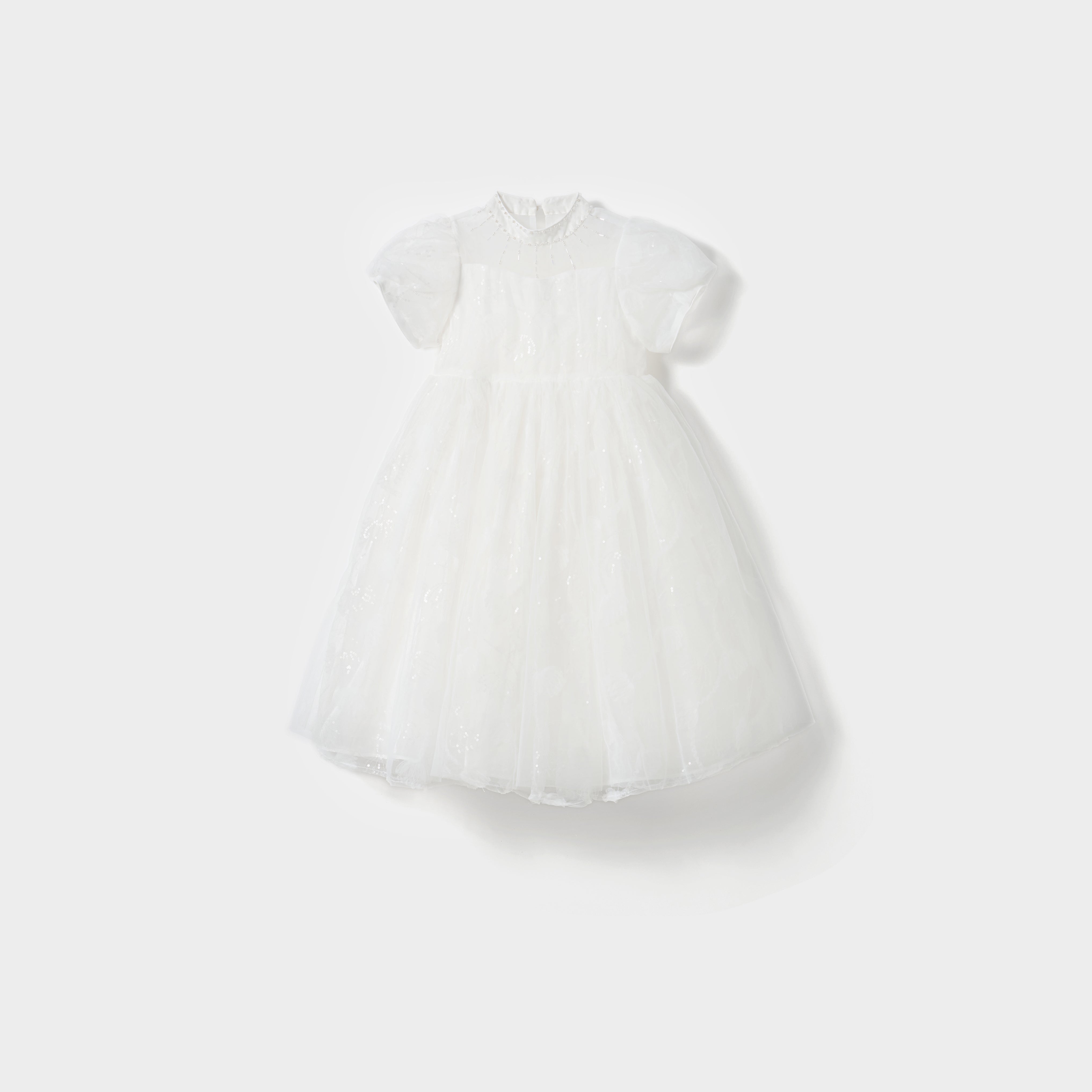 The Whisper Bloom Dress by KIKI and JOJO is a white, knee-length mini dress with short puffed sleeves, floral embroidery, bead accents, a fitted bodice, and a full tulle skirt shown against a plain white background.