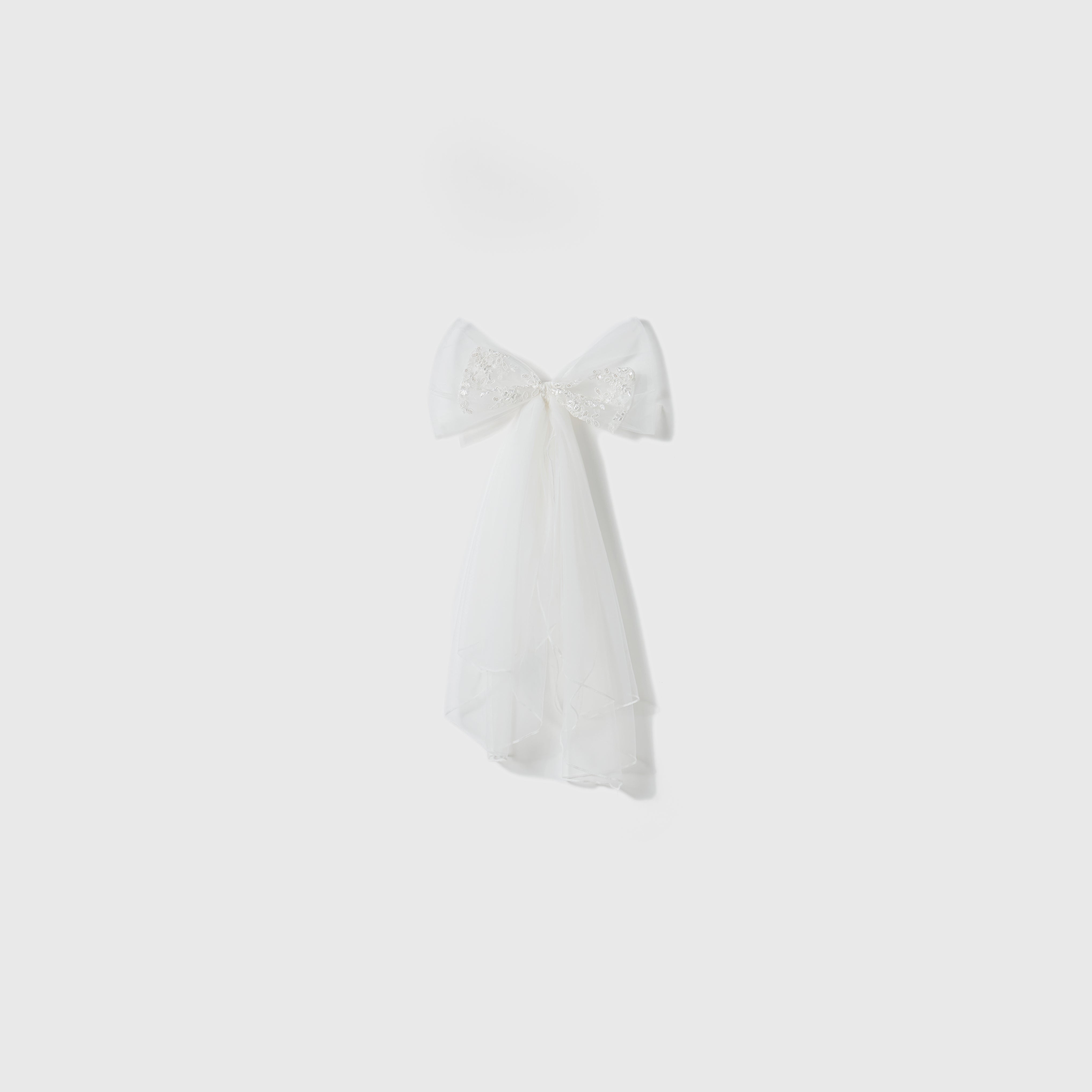 The Twinkle Whisper Dress by KIKI and JOJO features sheer fabric, decorative beading, and delicate embroidered lace, beautifully displayed against a plain light gray background.