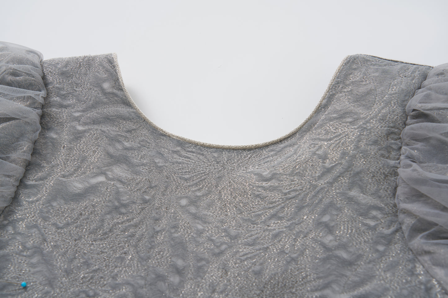 Close-up of the Dusk Whisper Dress by KIKI and JOJO, featuring a grey upper bodice with sheer, ruffled tulle puff sleeves, shown against a plain white background.