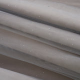 Close-up of the Dusk Whisper Dress by KIKI and JOJO: light gray sheer mesh fabric with scattered shiny sequins, elegantly draped—ideal for a glittering tulle look or a stylish grey puff-sleeve dress.