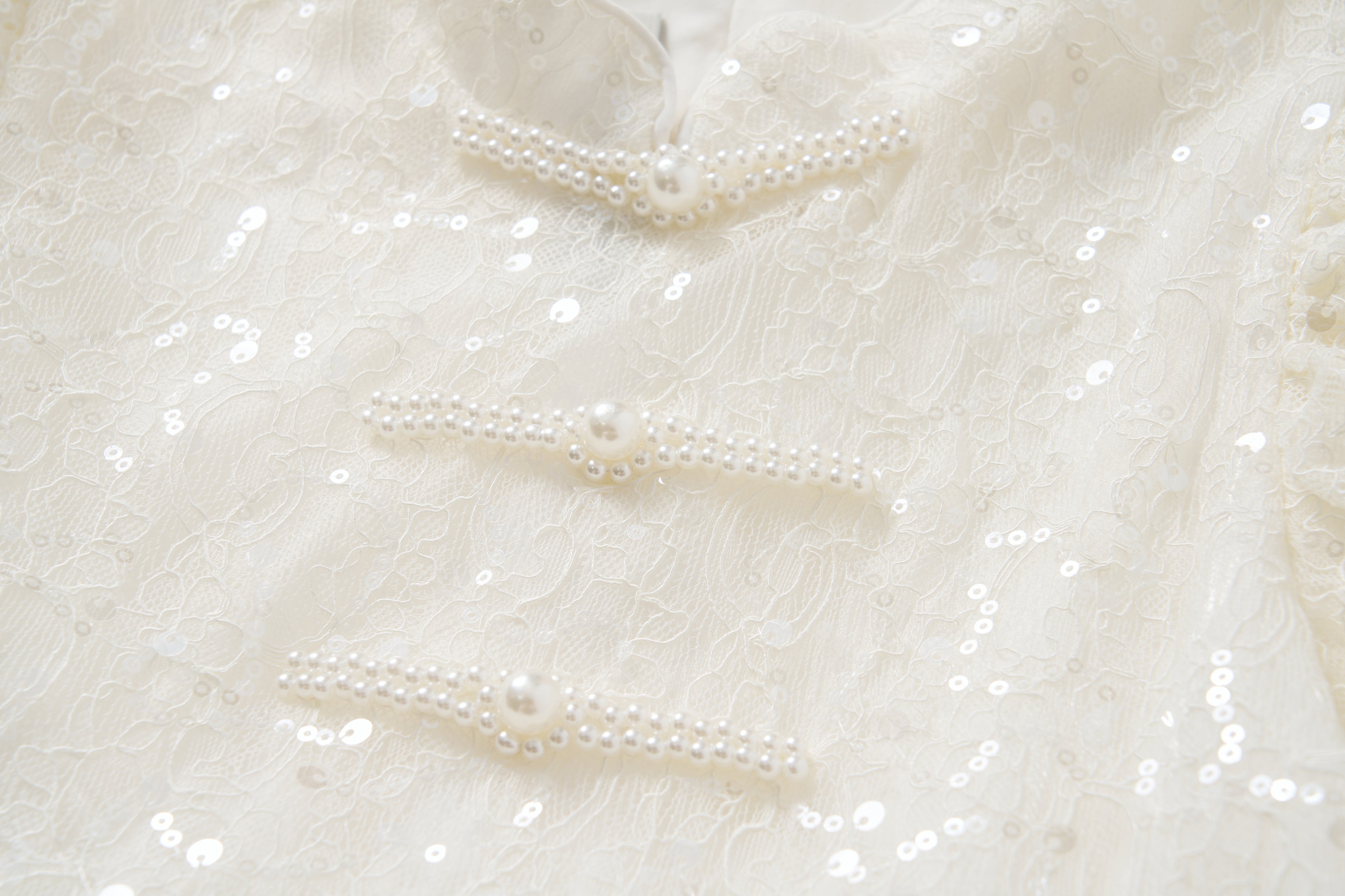 Close-up of sequin embroidered lace with three pearl bead buttons on the Orchid Whisper Dress by KIKI and JOJO—ideal for a modern vintage or elegant cheongsam-inspired look.