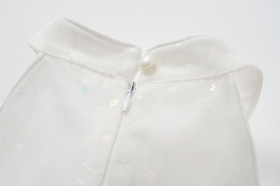 Close-up of the back of the KIKI and JOJO Butterfly Whispers Dress in white, featuring a halter style with a small zipper and button closure at the collar.