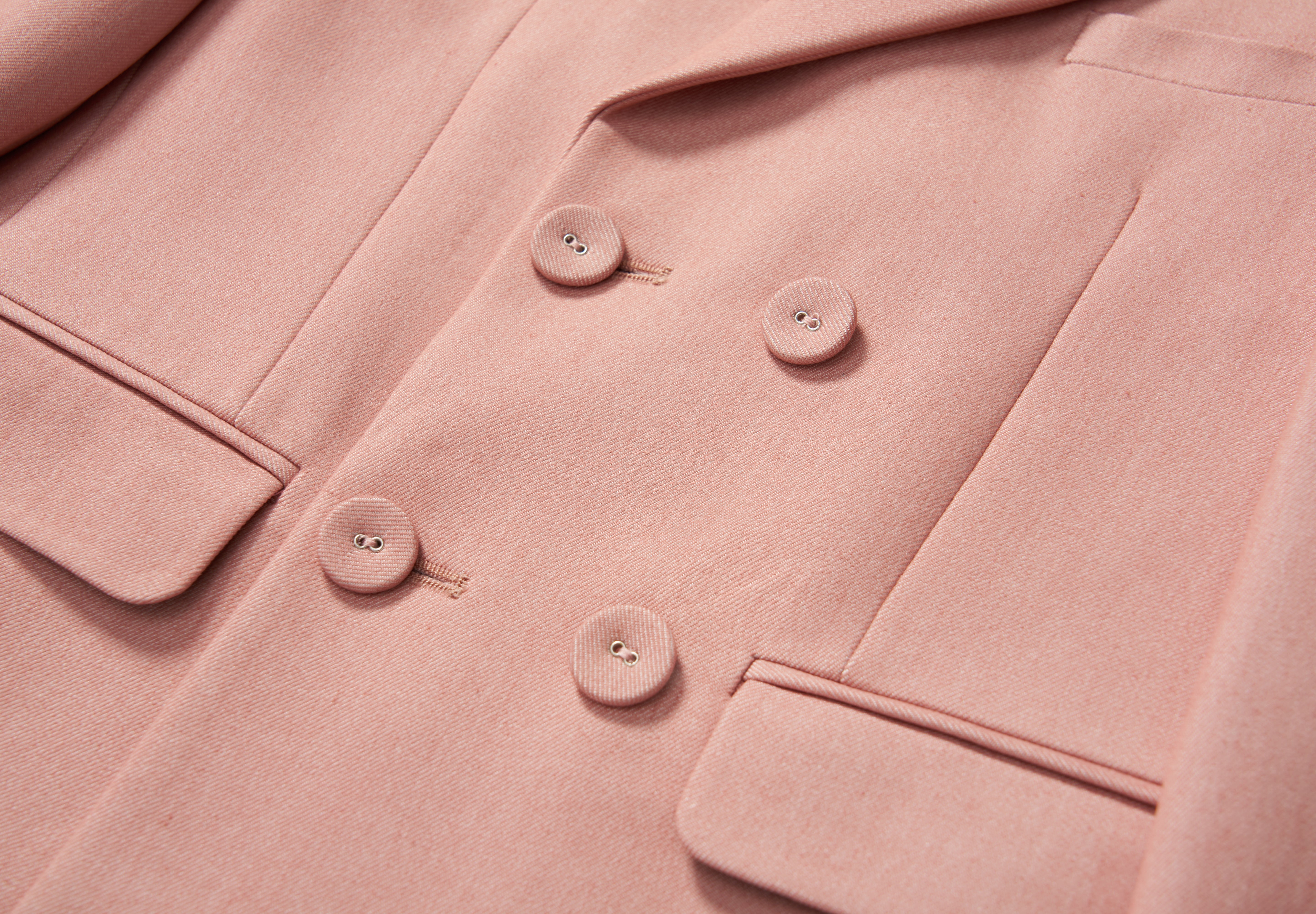 Close-up of the KIKI and JOJO Blush Reverie Suit Jacket, a blush pink, double-breasted boys blazer with lapel and two front pockets—perfect for special occasions.