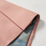 A close-up of the Blush Reverie Suit Jacket by KIKI and JOJO shows its folded blush pink exterior and striking blue silk lining with a gold paisley pattern, making it perfect for any boy’s special occasion.