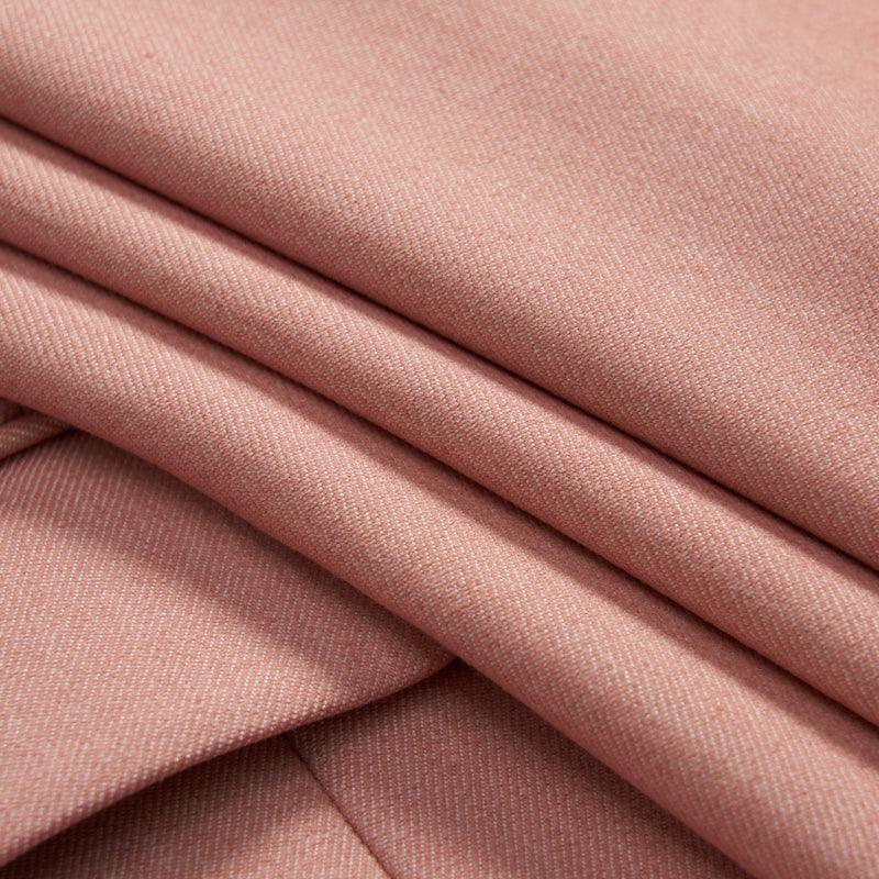 Close-up of folded light pink fabric with a smooth texture and subtle diagonal weave pattern.
