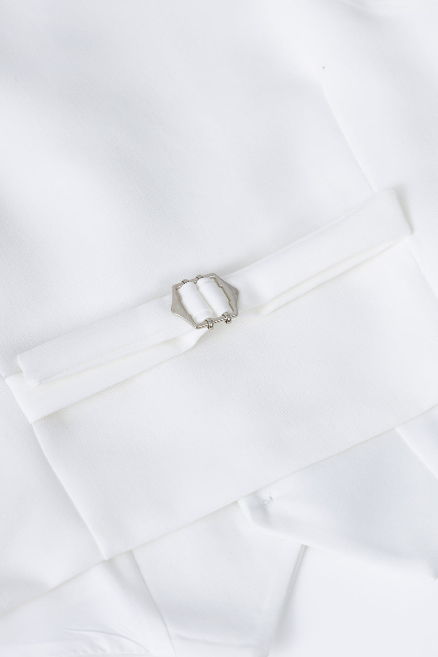 A detailed view of the KIKI and JOJO Kids Suit – White 3-Piece Set (3-14 Years, Classic Fit, Wrinkle-Free)—showing a silver rectangular buckle and decorative folded band—ideal for weddings.