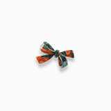 The Girls Bow Hair Clip - Nature Palette by KIKI and JOJO features a small, glossy bow in red and black with a pearlescent brown gradient, displayed against a white background.