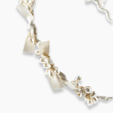 The KIKI and JOJO Girls Bow Hairband - Pearl features a cream fabric design adorned with elegant bow details and rows of pearl beads, perfect for adding charm to any girl's look.