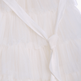 Close-up of the KIKI and JOJO Girls Embroidered Satin & Tulle Dress in ivory, featuring layered tulle and a sash tied at the waist—ideal for special occasions.