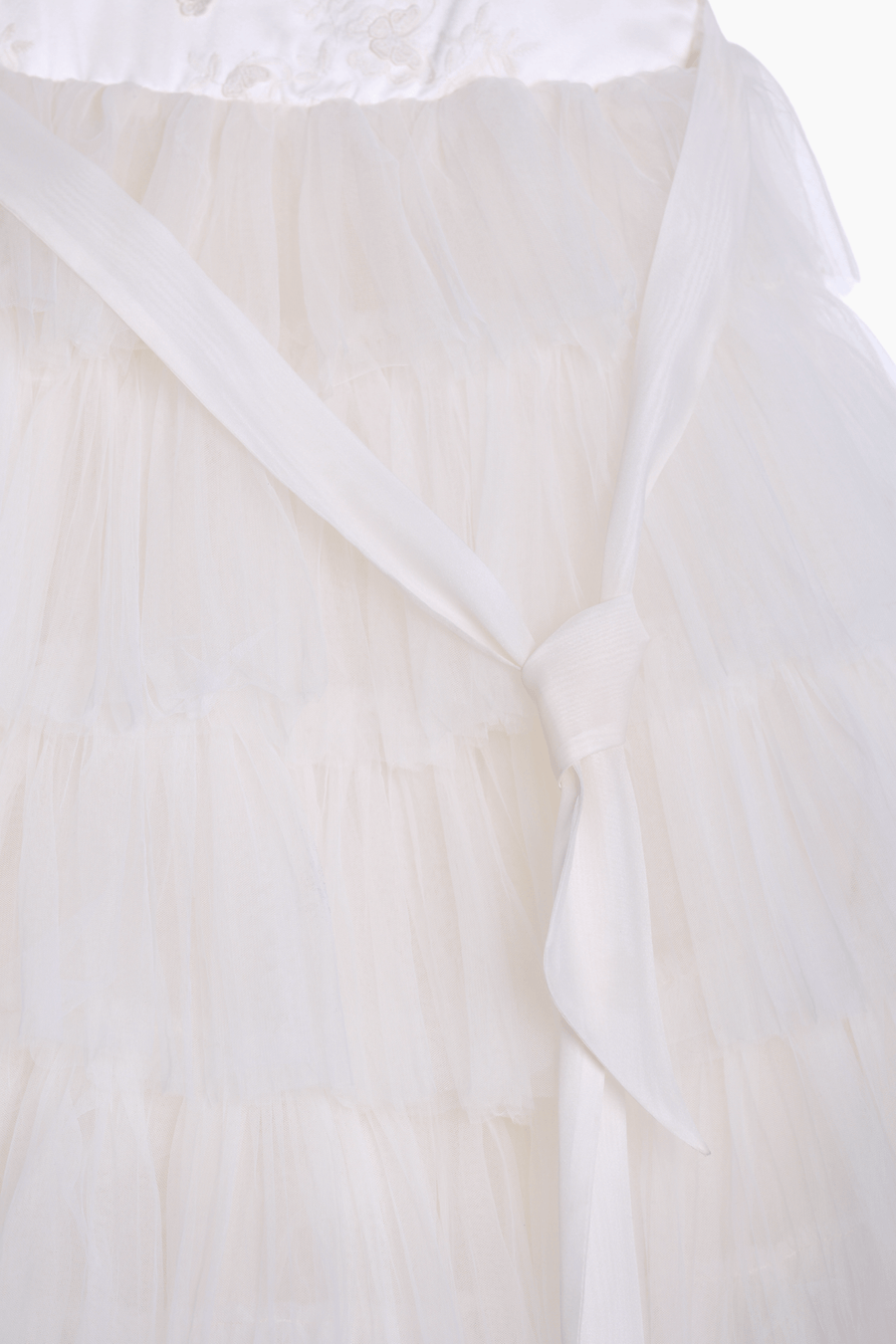 Close-up of the KIKI and JOJO Girls Embroidered Satin & Tulle Dress in ivory, featuring layered tulle and a sash tied at the waist—ideal for special occasions.