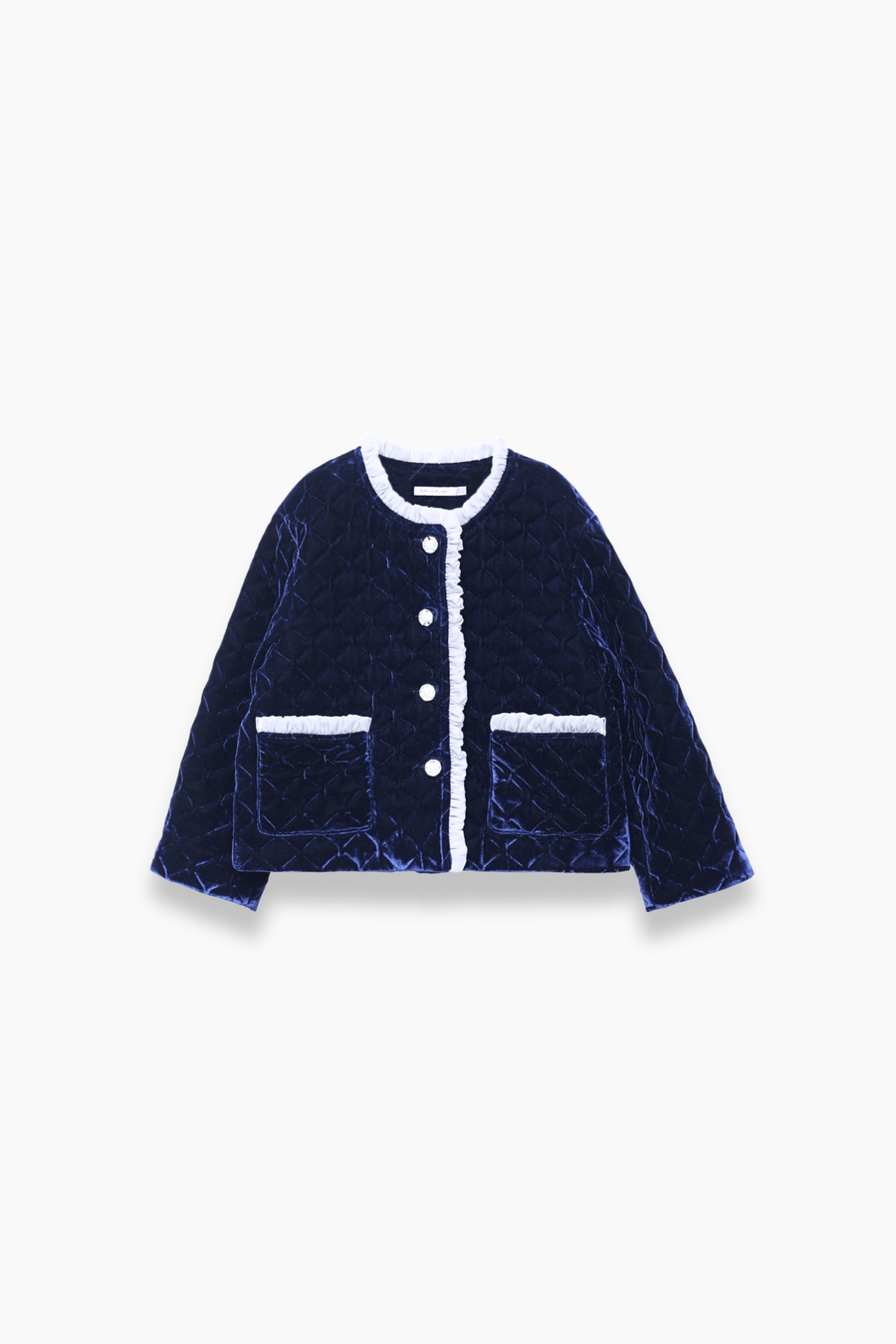 The KIKI and JOJO Girls Quilted Ruffle Jacket in Sapphire Blue features a diamond-quilted design, white trim, petal-shaped buttons, and two front pockets, shown on a plain white background.