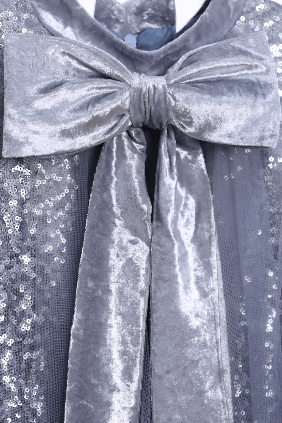 Close-up of a large silver velvet bow on the shimmering sequin embroidery of the KIKI and JOJO Girls Sequin Tulle Dress in Starlight Blue.