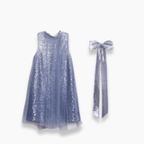 The KIKI and JOJO Girls Sequin Tulle Dress in Starlight Blue features sleeveless sequin embroidery with a tulle overlay, shown next to a coordinating silver velvet bow.