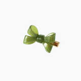 The KIKI and JOJO Girls Sheer Double Bow Hair Clip in Moss Olive features an iridescent green double bow with pearl-like shimmer and a gold metal clasp, shown on a white background.